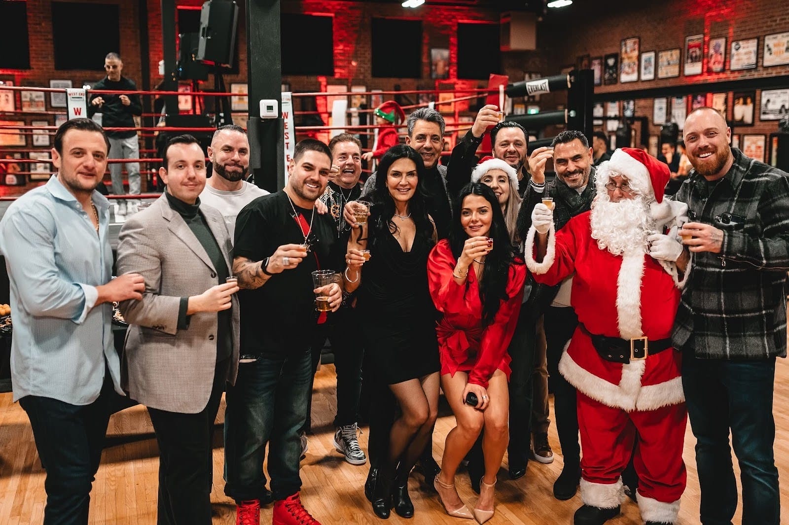 West End Athletic Club staff holding drinks in a cheers in front of the boxing ring at the Toronto boxing and fitness gym.