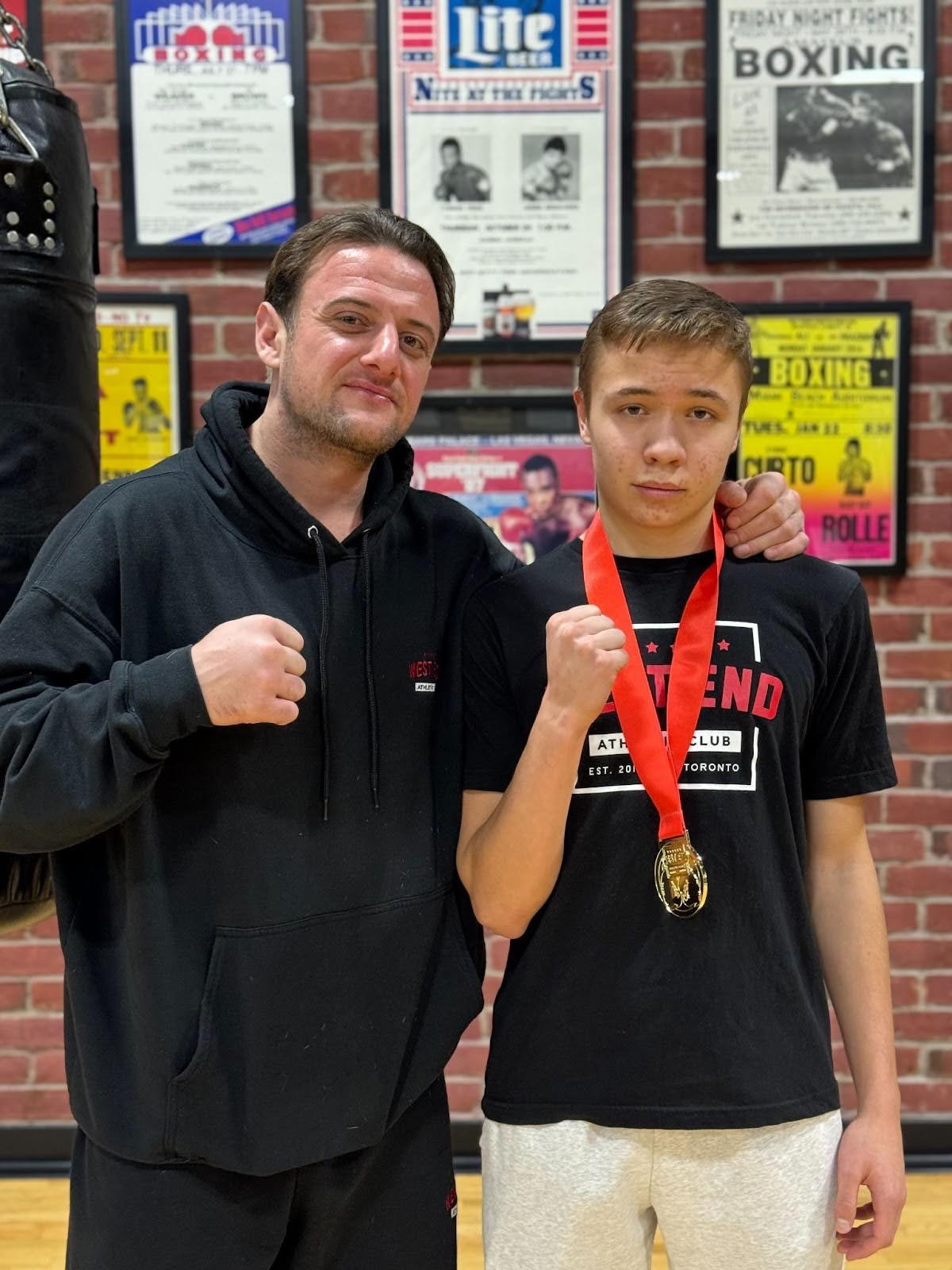 Vinny Cappuccitti standing beside Misha Ideltchik who is wearing a medal around his neck and a West End Athletic Club t-shirt.